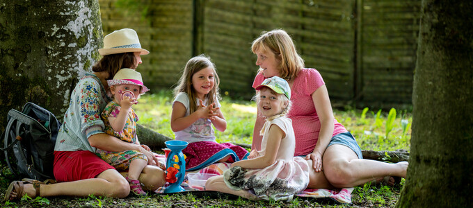 Zwei Frauen und drei Kinder sitzen im Sommer im Park | © Bernd Ritschel